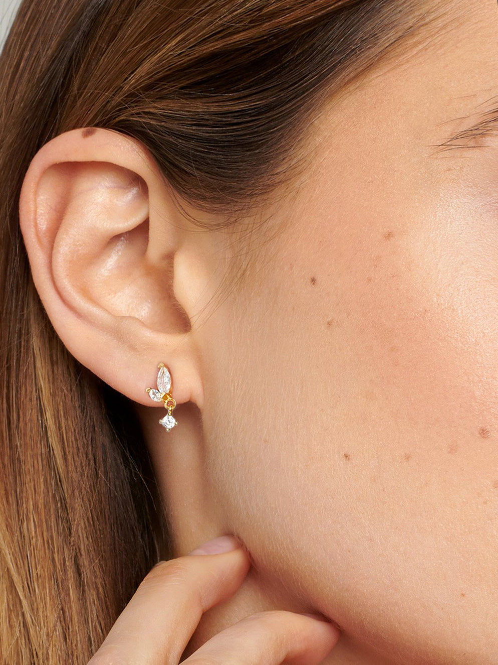 Small marquise stud earrings in gold with a dangling charm.