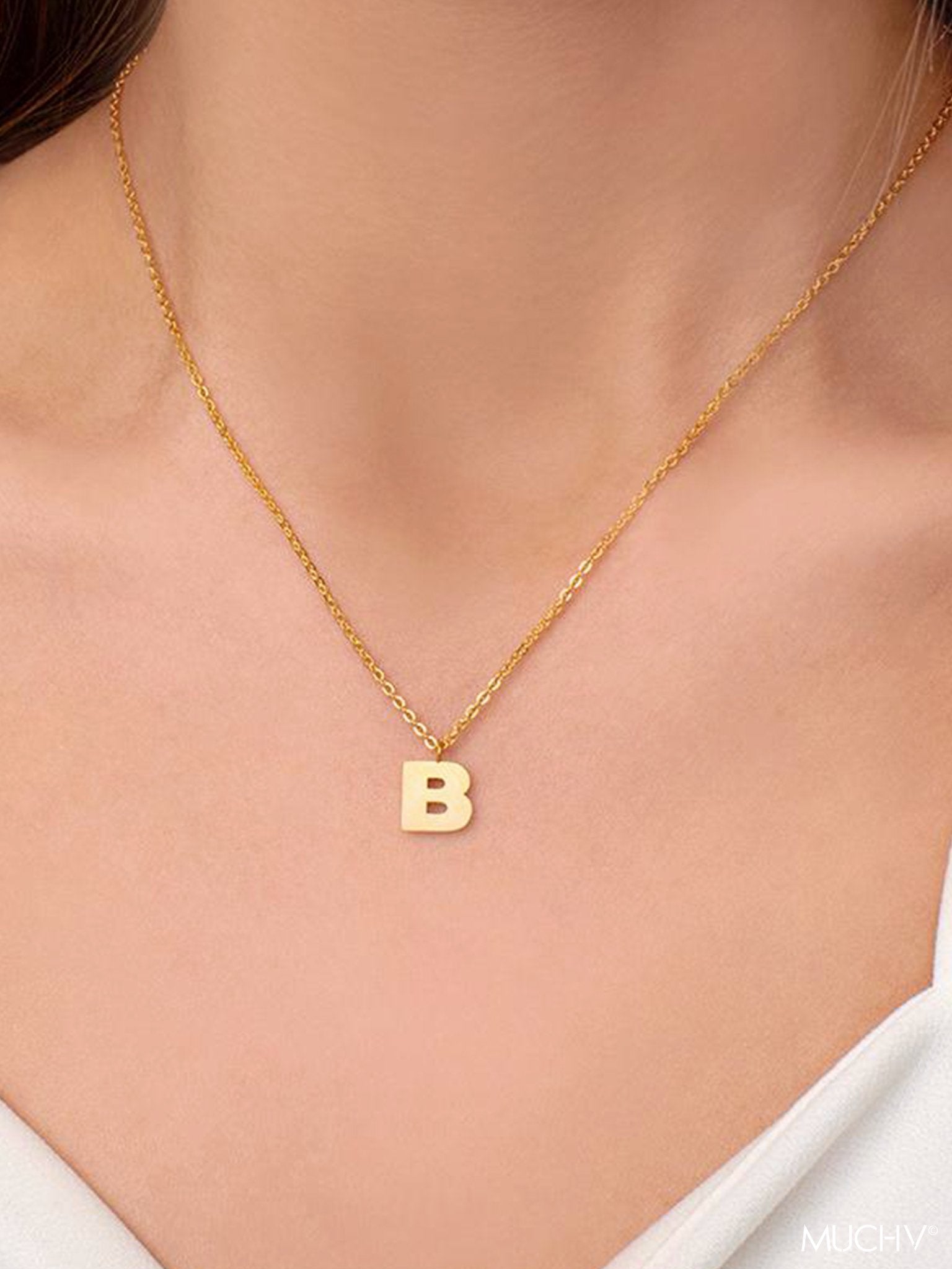 Gold necklace with a small initial letter.