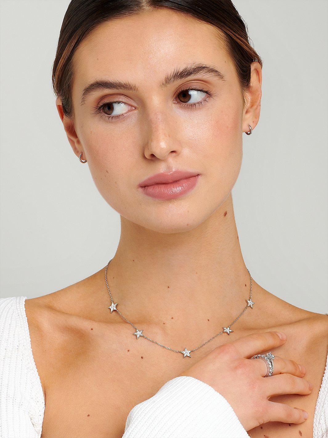 Model wearing a sterling silver necklace with five star charms.
