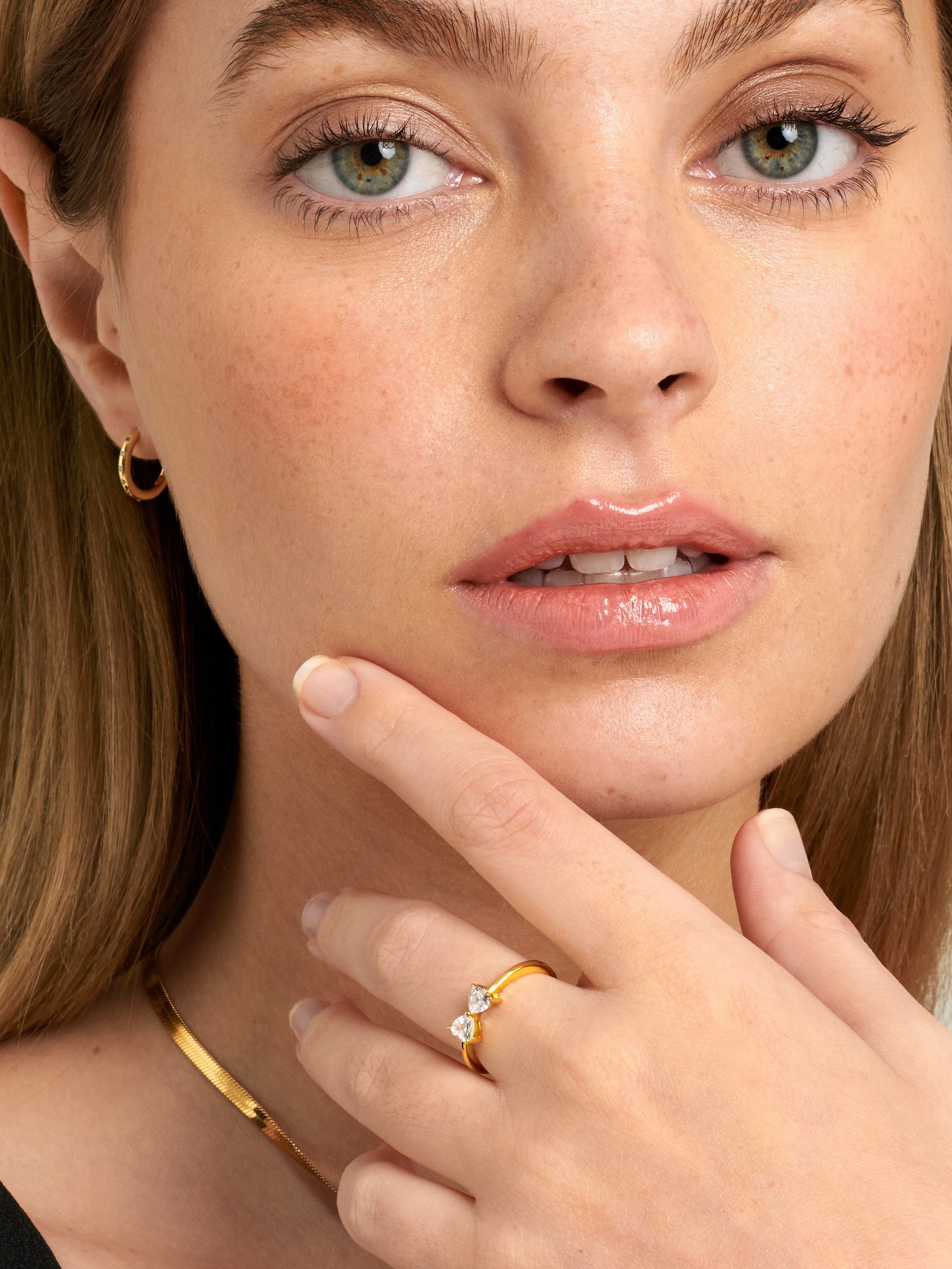 Teenage model wearing a gold heart ring.