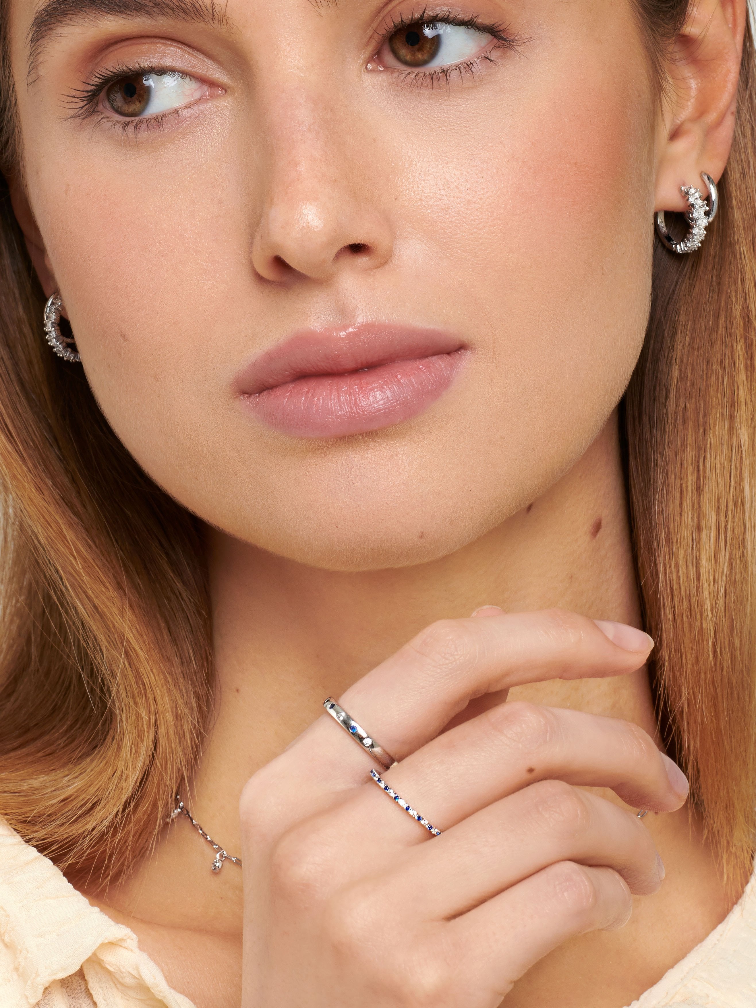 Female model wearing sterling silver rings for women with blue stones.