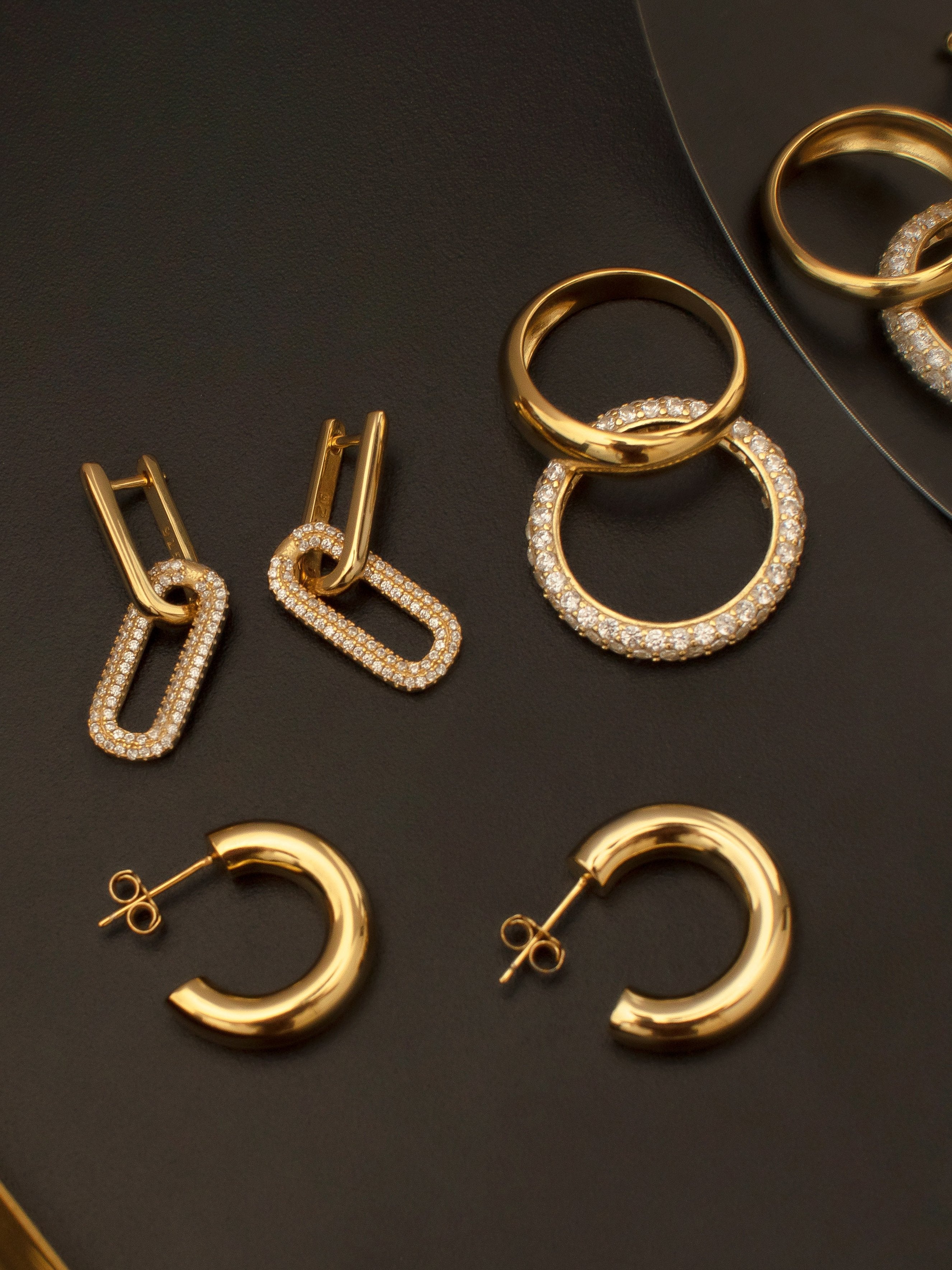 Gold dome rings paired with hoop earrings for women.