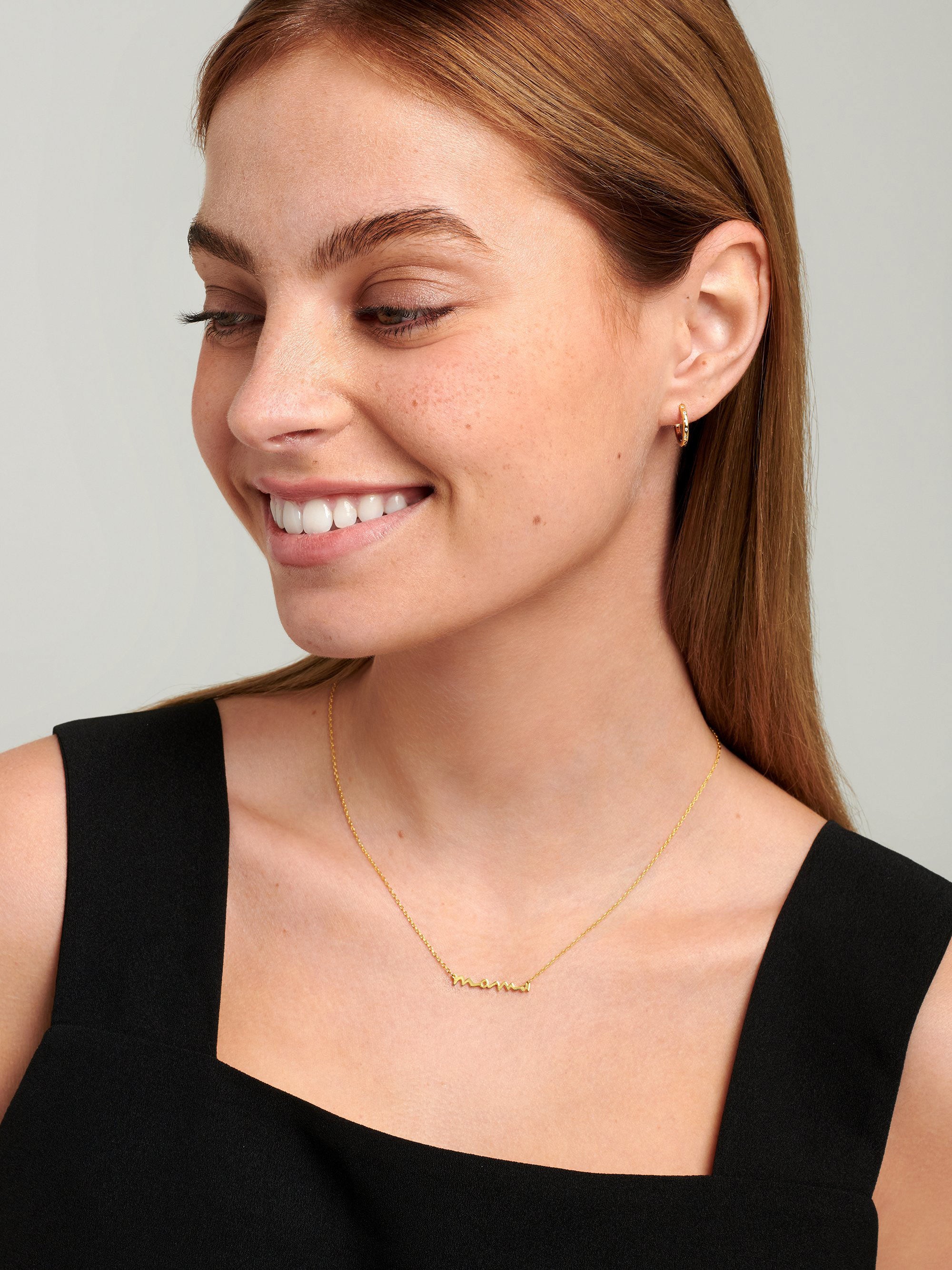 Model wearing script necklace with the word mama in a handwritten style.