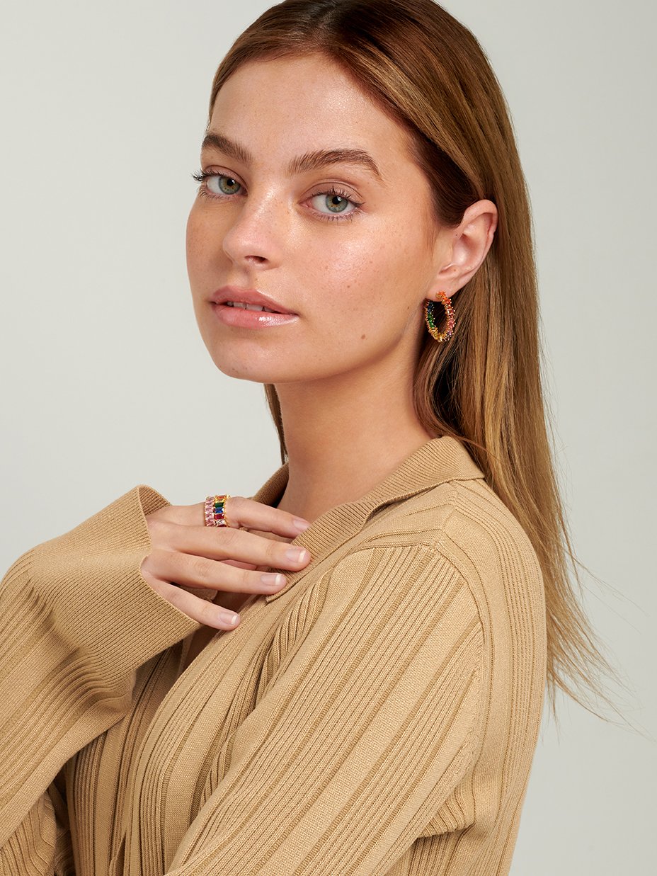 Teenage model wearing large hoop earrings with colourful stones.