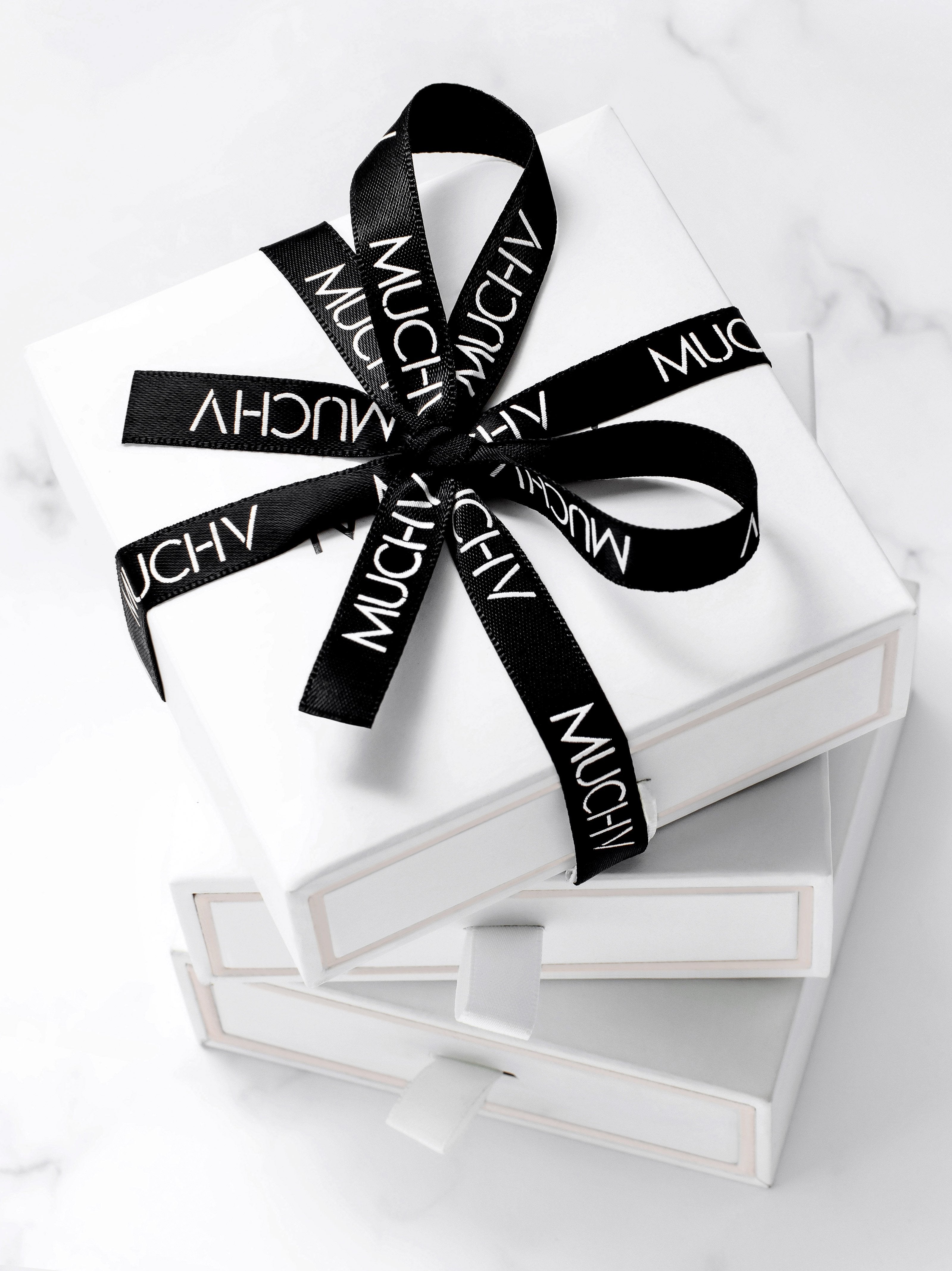White gift box with a black satin ribbon.